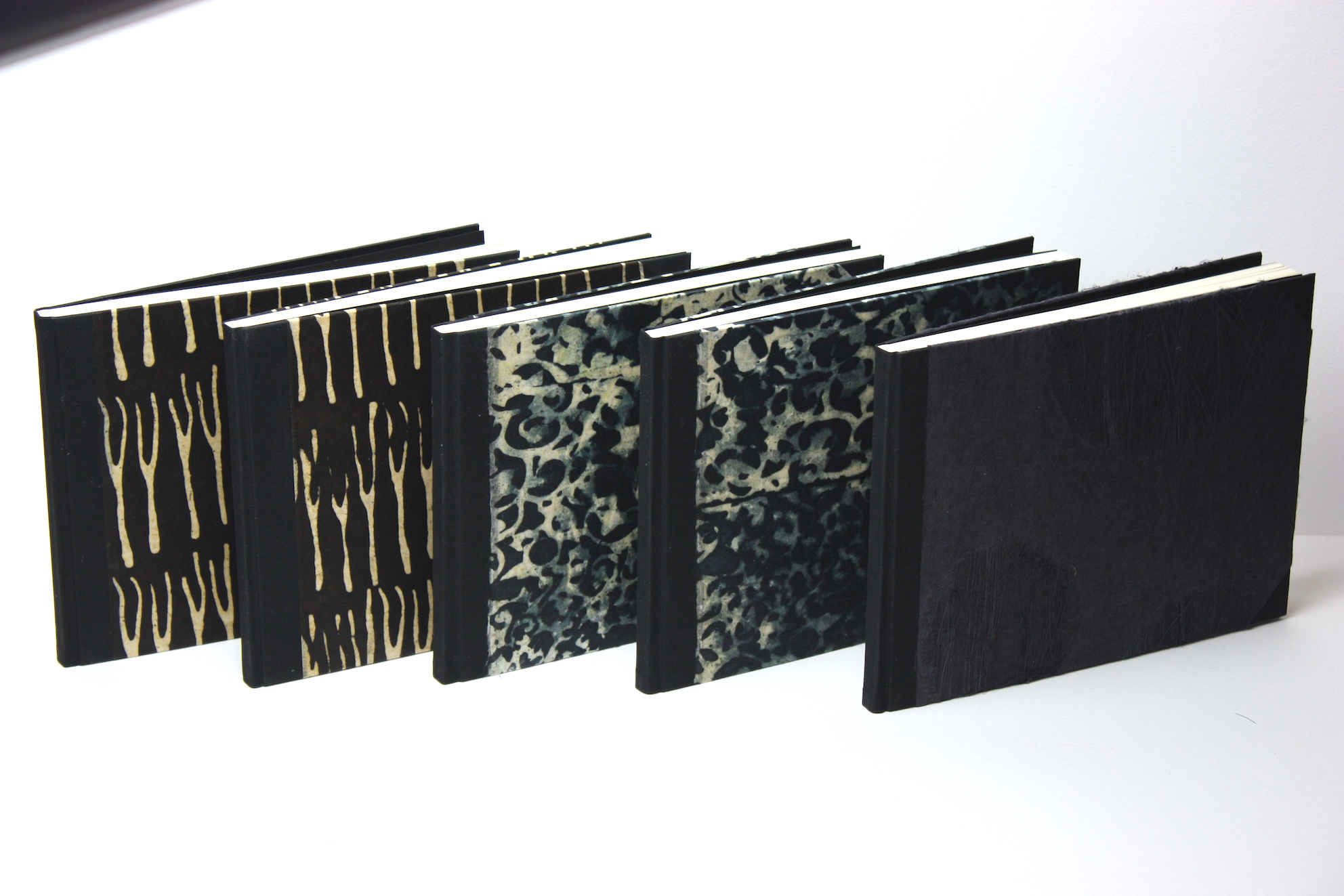 Notitieboekjes gekartonneerd geheel ingeslagen linnen rug hoekjes zwart lokta papier batikpapier hand gemaakt