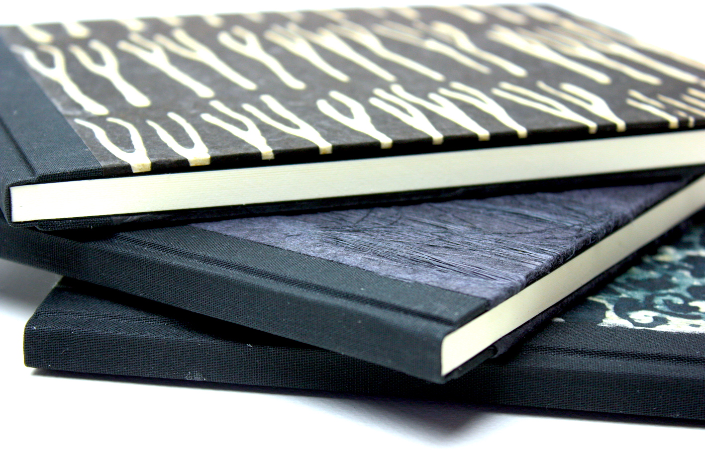Notitieboekjes gekartonneerd geheel ingeslagen linnen rug hoekjes zwart lokta papier batikpapier hand gemaakt
